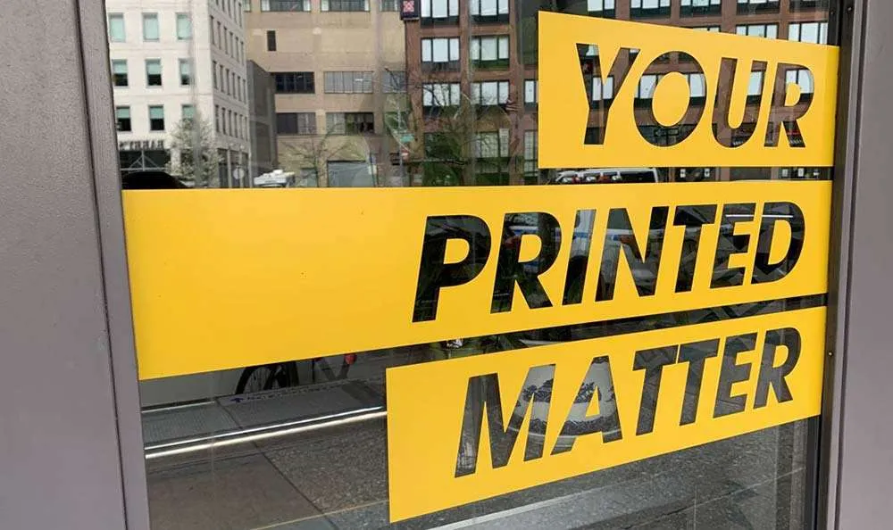 Glass door signage with "Your Printed Matter" in yellow