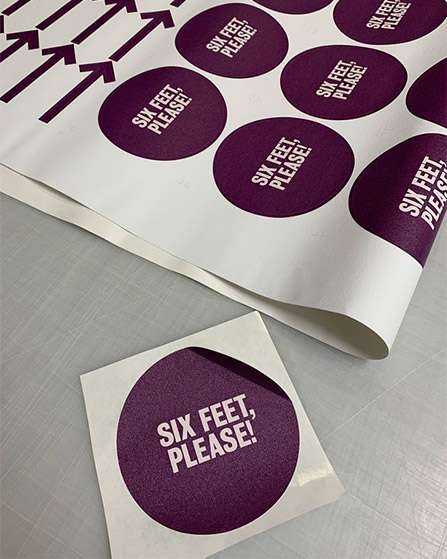 Purple stickers that say six feet, please