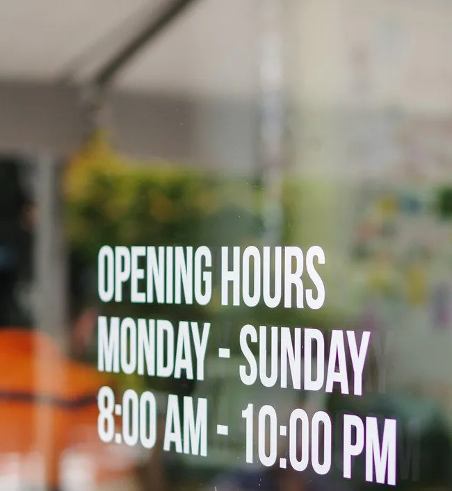 Blurred glass door with hours of operation Monday - Sunday 8:00 AM to 10:00 PM